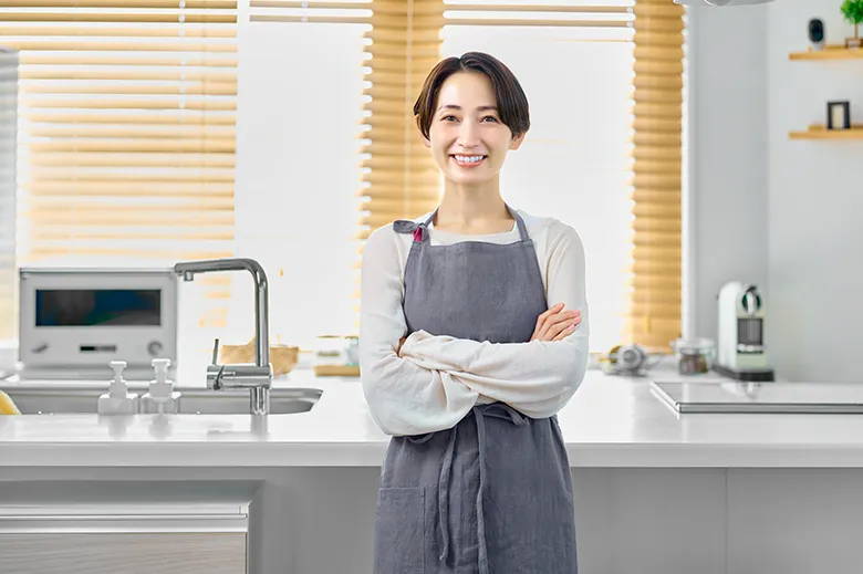 キッチンで腕を組んで微笑む女性